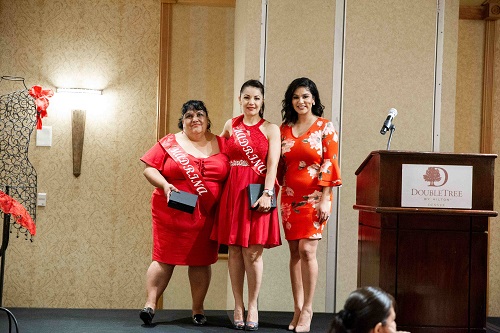 Photo of three ladies in red on stage